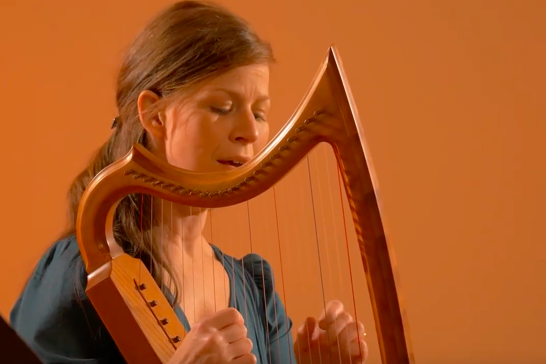 Allison Mondel singing and playing a Celtic harp.